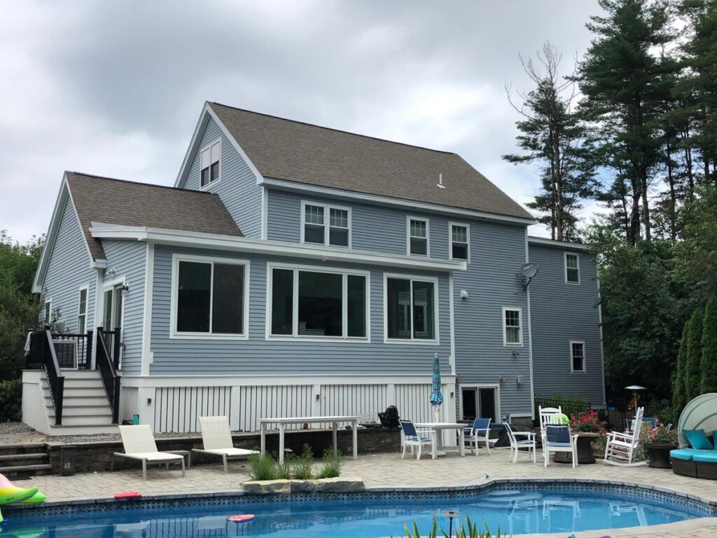 Exterior shot of home addition, in ground pool with stone patio
