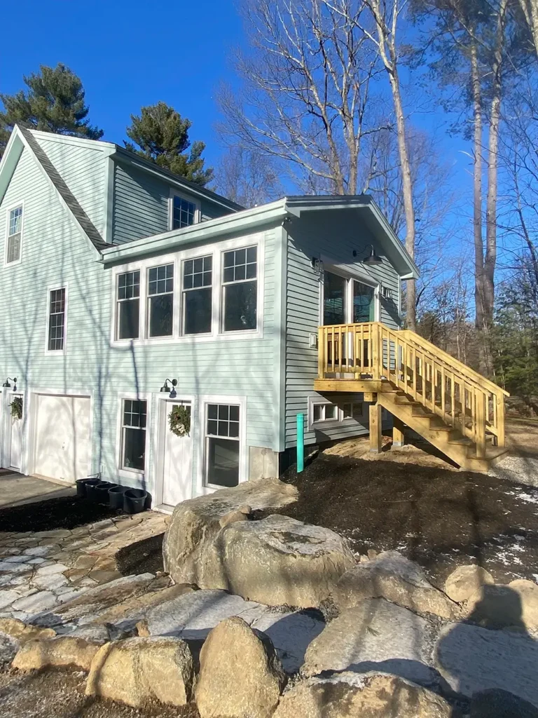 Home addition entryway with staircase and landscaping