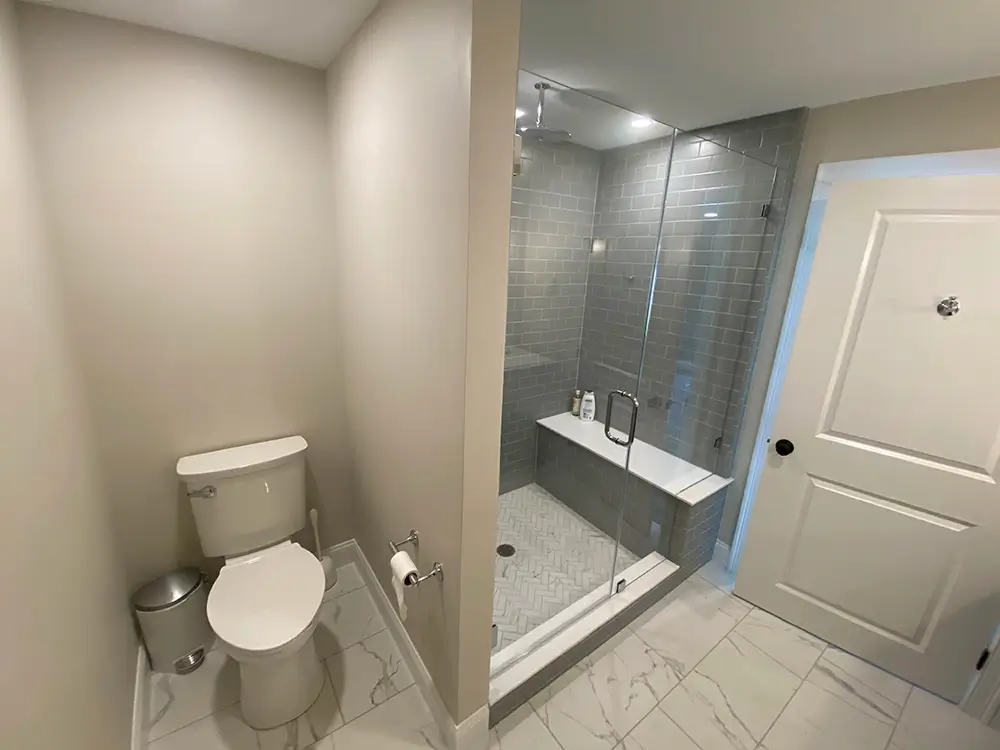 Newly remodeled bathroom interior with tile shower and glass door