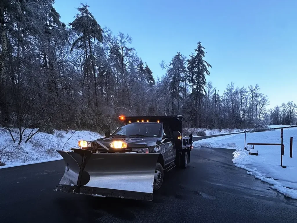 Pick up truck with plow clearing driveway