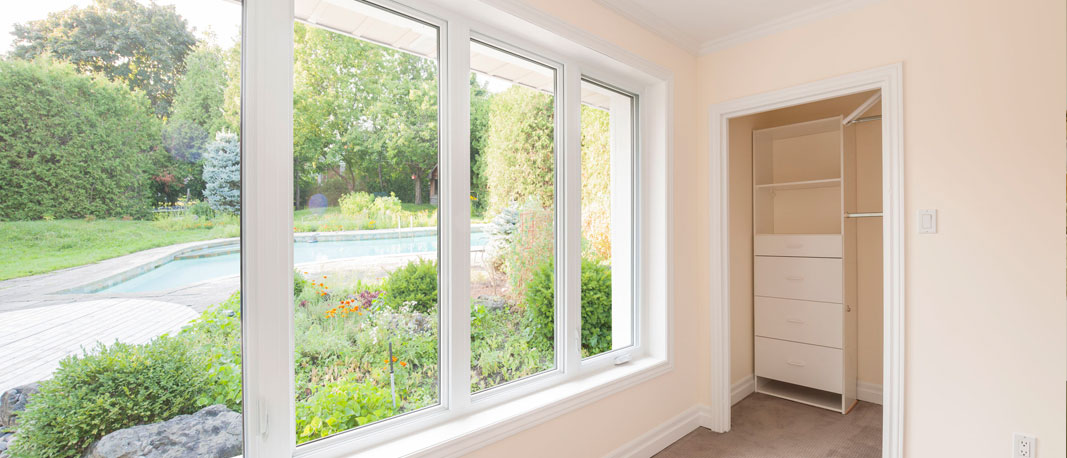 Home interior showing closet with organizer, large windows with exterior land landscaped garden and pool view